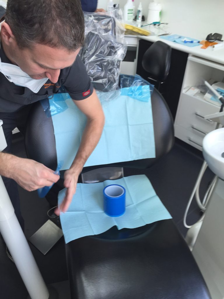 Doctor Jeremy sticks paper dental clothes to the chair to protect my clothes from second hand fragrance